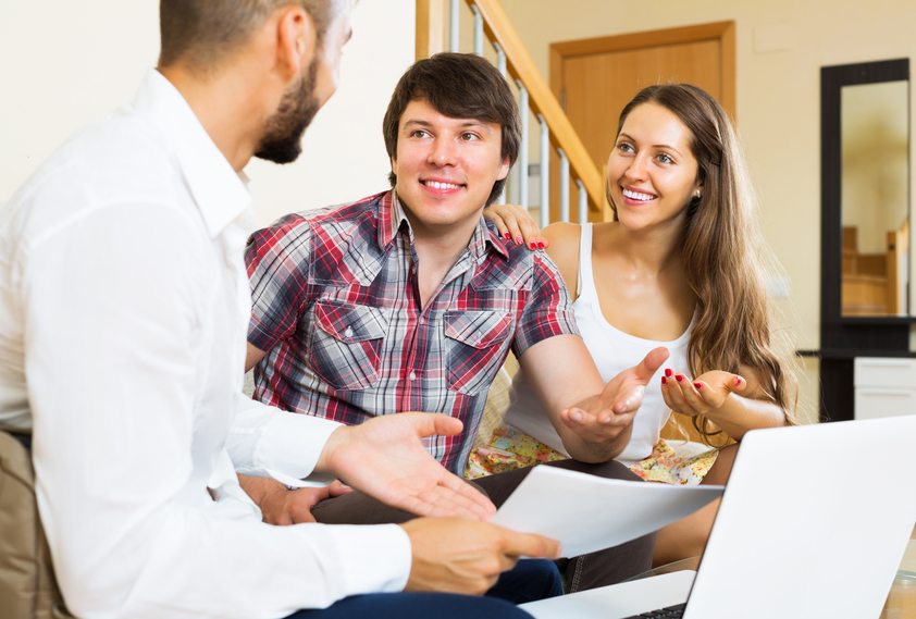 Positive couple and salesman talking cheerfully about purchase at home