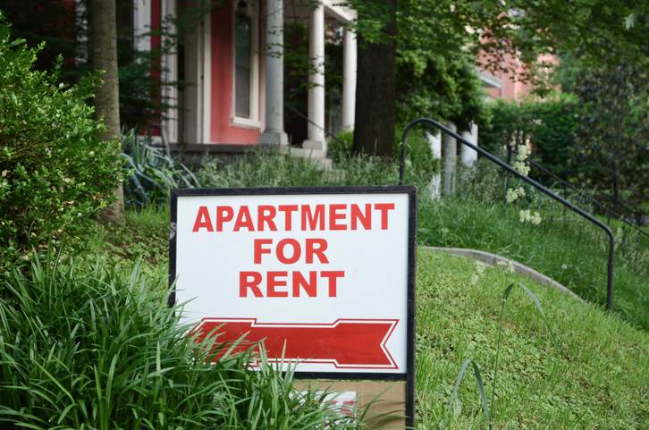 Apartment for rent sign displayed on residental street. Shows demand for housing, rental market, landlord-tenant relations.